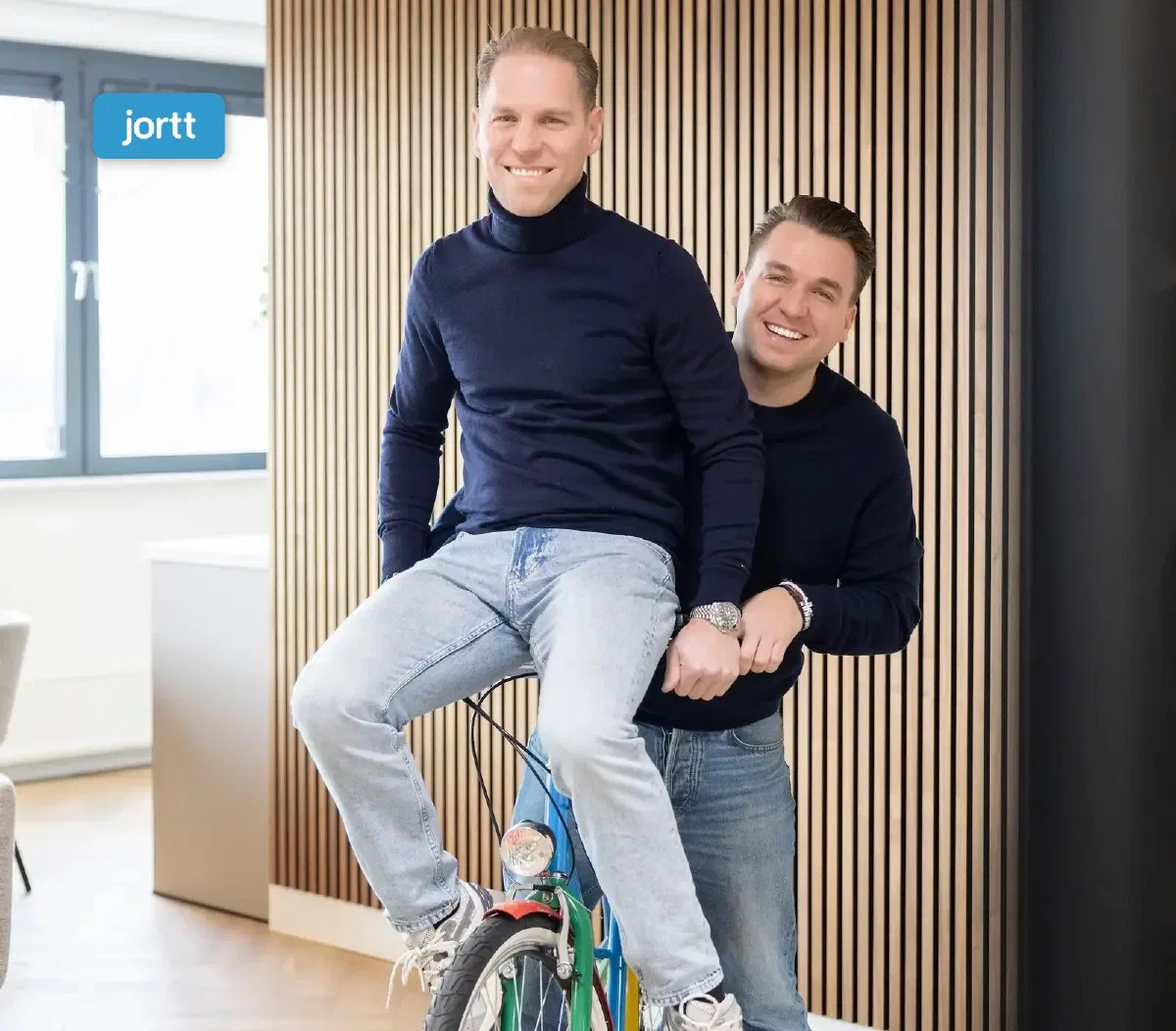 Philip Stibbe en Sander, de twee eigenaren van hello it's me, op een fiets in hun kantoor in Almere