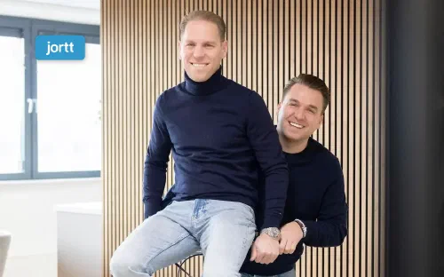 Philip Stibbe en Sander, de twee eigenaren van hello it's me, op een fiets in hun kantoor in Almere