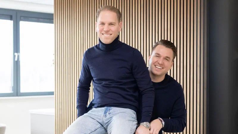 Philip Stibbe en Sander, de twee eigenaren van hello it's me, op een fiets in hun kantoor in Almere